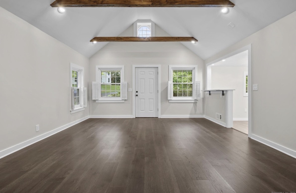 Bright renovated living room with vaulted ceiling and exposed wood beams