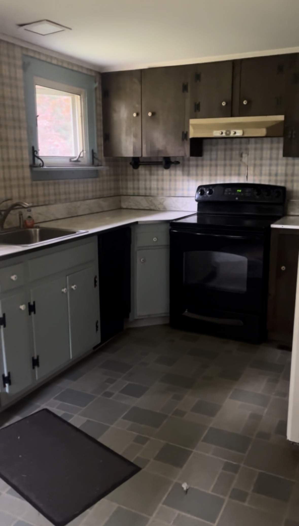 Kitchen before renovation — dated cabinets and flooring